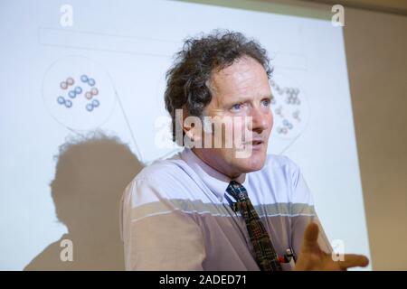 Secondary School teacher standing in front of a whiteboard explaining the background to car combustion and air quality, part of a core module of a sci Stock Photo