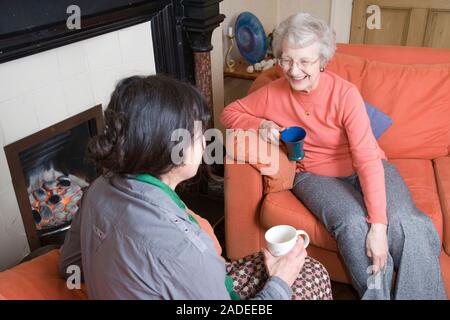 IndependentAge volunteer and older woman enjoying a cup of tea together. Stock Photo