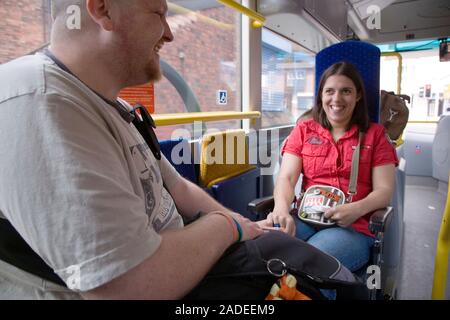 Young woman with cerebral palsy in a wheelchair with her boyfriend on a bus. Stock Photo