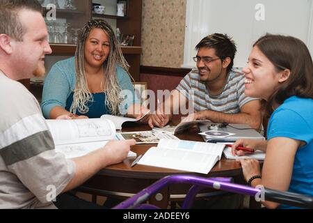 Multiracial group of students in study group, one has cerebral palsy and uses a walking frame. Stock Photo