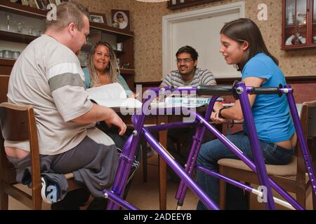 Young white student, who has cerebral palsy and uses a walking frame, in multiracial study group. Stock Photo