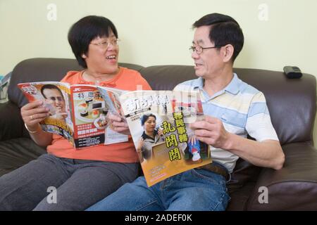 Couple reading Chinese magazines together. Stock Photo