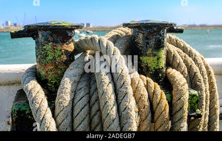 Weathered rope wrapped around a bollard on a ferryboat Stock Photo