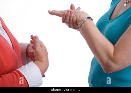 Two women using sign language to communicate. Stock Photo