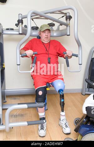 Man with prosthetic limb using the chest press at a gym. Stock Photo