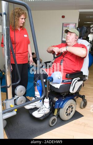 Man with prosthetic limb using pulley machine at a gym. Stock Photo