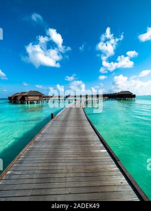 Footbridge over shallow water with water bungalows, island in the south Male Atoll, Maldives Stock Photo
