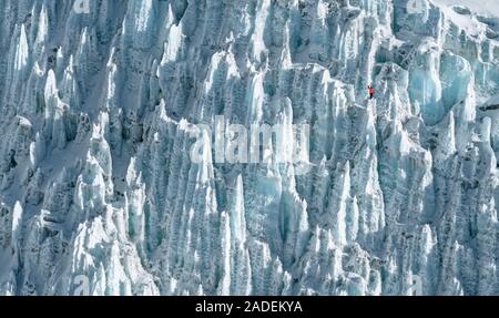 Aerial view of Khumbu icefall with a climber figure standing on a steep ice slope. Everest peak climbing area Stock Photo
