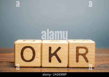Wooden blocks with the word OKR ( Objectives and Key Results ). Team and individual goals. Effective control over the implementation of tasks. Busines Stock Photo