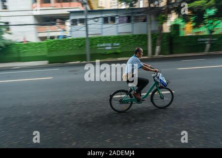 Chengdu, China -  July 2019 : Chinese man cycling on a on an empty street in town Stock Photo