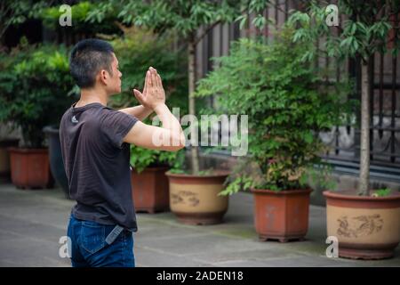 Chengdu, China - July 2019 : Chinese man praying and worshiping at the Wenshu Chinese Buddhist Temple Stock Photo