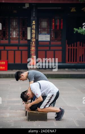 Chengdu, China - July 2019 : Chinese men praying and worshiping at the Wenshu Chinese Buddhist Temple Stock Photo