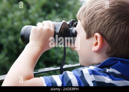 Boy looking through binoculars. Stock Photo