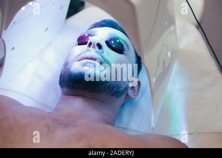 Face of bearded man lying in protective glasses Stock Photo