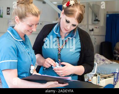 This is a real situation. Image not to be used in a defamatory context. Hospital respiratory ward. Enablement workers discussing patients on the respi Stock Photo