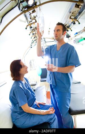 MODEL RELEASED. Hyperbaric oxygen therapy. Medical workers training in the use of hyperbaric oxygen therapy, a treatment that can be used for a range Stock Photo