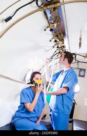 MODEL RELEASED. Hyperbaric oxygen therapy. Medical workers training in the use of hyperbaric oxygen therapy, a treatment that can be used for a range Stock Photo