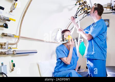 MODEL RELEASED. Hyperbaric oxygen therapy. Medical workers training in the use of hyperbaric oxygen therapy, a treatment that can be used for a range Stock Photo