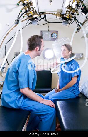 MODEL RELEASED. Hyperbaric oxygen therapy. Medical workers training in the use of hyperbaric oxygen therapy, a treatment that can be used for a range Stock Photo