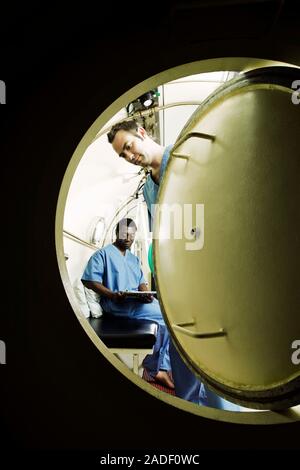MODEL RELEASED. Hyperbaric oxygen therapy. Medical workers training in the use of hyperbaric oxygen therapy, a treatment that can be used for a range Stock Photo