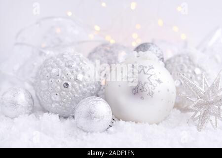 Christmas decorative balls on snow and Christmas lights. Festive Christmas background Stock Photo