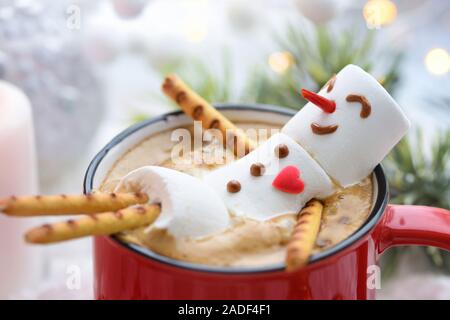 Red mug with cappuccino with melted marshmallow snowman Stock Photo