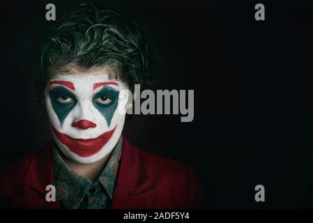 boy dressed as Joker on dark background Stock Photo