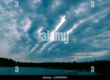Altocumulus. A deck of altocumulus clouds. These are mid-level water clouds which often form ordered 'streets' or wave patterns as seen here. The clou Stock Photo