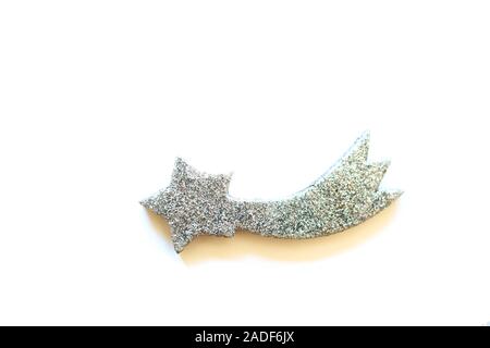 Minimal composition with sparkling handmade silver shooting star toy, isolated on white background. New Year and Christmas concept. Stock Photo