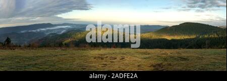 Sunrise winter panorama in the Black Forest Mountains at a place called Zuflucht with some fog and cloudy sky Stock Photo