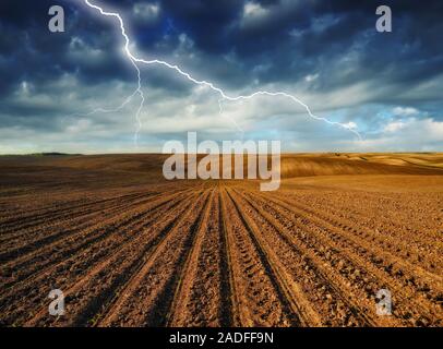 lightning over the field. picturesque hilly field Stock Photo