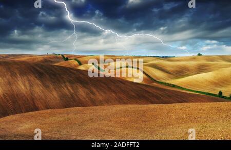 lightning over the field. picturesque hilly field Stock Photo
