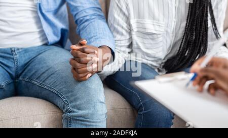 Unrecognizable Married Couple Holding Hands During Therapy Session In Counselor's Office Stock Photo