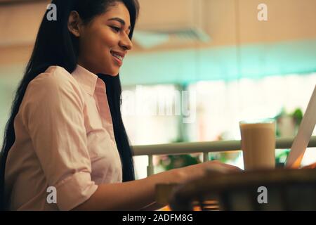 Close up of long haired lady sitting and smiling Stock Photo