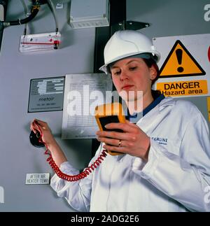 Air pollution monitoring. Technician monitoring the air in a building's air handling unit. This device cleans and recycles a building's air, removing Stock Photo