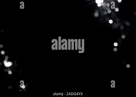 Abstract bokeh made from silver glitter on black background. Holiday concept, copy space. Stock Photo