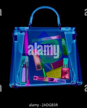 Handbag. Coloured X-ray of a woman's handbag showing the contents. The contents include various cosmetics: perfume bottle, eyeliner pencil, mascara wi Stock Photo
