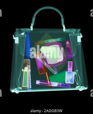 Handbag. Coloured X-ray of a woman's handbag showing the contents. The contents include various cosmetics: perfume bottle, eyeliner pencil, mascara wi Stock Photo