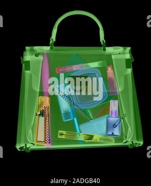 Handbag. Coloured X-ray of a woman's handbag showing the contents. The contents include various cosmetics: perfume bottle, eyeliner pencil, mascara wi Stock Photo