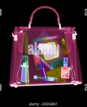 Handbag. Coloured X-ray of a woman's handbag showing the contents. The contents include various cosmetics: perfume bottle, eyeliner pencil, mascara wi Stock Photo