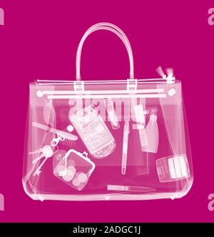 Handbag, coloured X-ray. Its contents include make-up, a purse, keys, pens and a mobile phone. Stock Photo