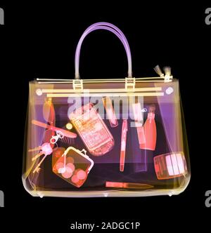 Handbag, coloured X-ray. Its contents include make-up, a purse, keys, pens and a mobile phone. Stock Photo