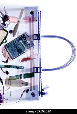 Handbag, coloured X-ray containing a mobile phone, hair brush, keys, a pen and cosmetics. Stock Photo