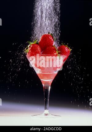 A glass containing ripe strawberries being showered with water. Stock Photo