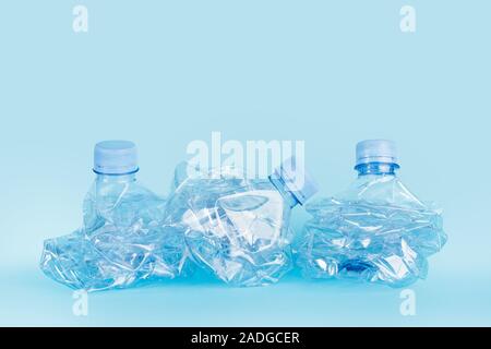 Crushed empty water bottles on a blue background Stock Photo
