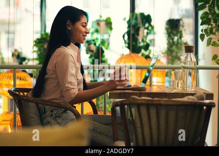 Confident young lady using laptop in the cafe Stock Photo