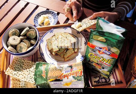 Algae food products. Tray of various biscuit and bread products that have seaweed and other algae in them. Butter is being spread on a biscuit to be e Stock Photo