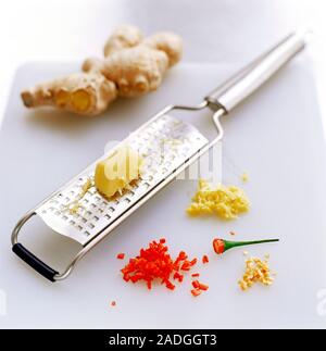 Grated spices. Ginger on a grater next to chopped red chilli, chopped chilli and whole ginger. Stock Photo