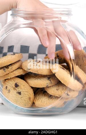 Cookie jar. Boy reaching into a jar of cookies. Stock Photo
