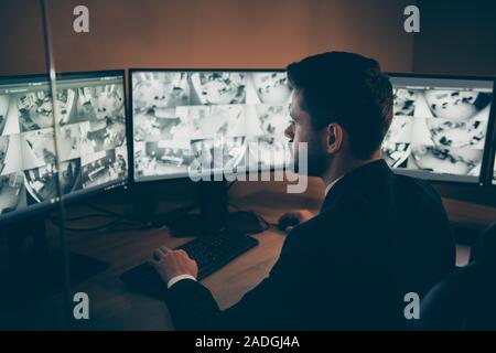 Profile side view portrait of his he nice attractive serious focused professional guy providing remote safe safety service supervising tv panel at Stock Photo